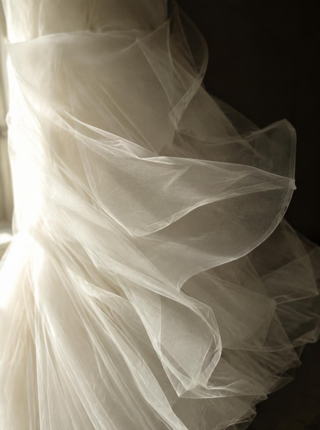 Bridal tulle detail, ivory fabric caught in motion under soft light