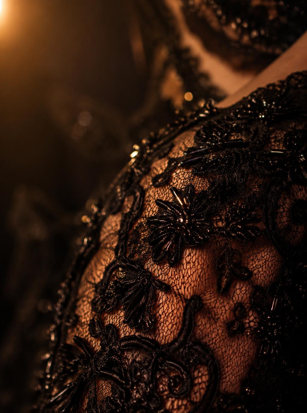 Close crop of black lace and crystal beadwork on skin